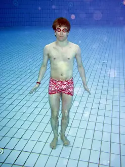 Pools: Man swimming underwater in a swimming pool wearing goggles