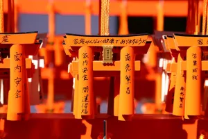 Wooden: Miniature red torii gates with prayers at Fushimi Inari Shinto shrine in Kyoto, Japan