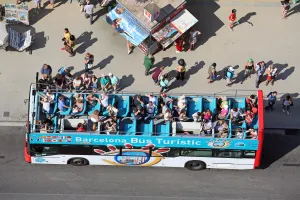 Tourism: Open top sightseeing tour bus and tourists, Barcelona, Spain