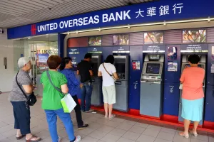 Money: People using the ATM cashpoint machines at the United Overseas Bank in Singapore