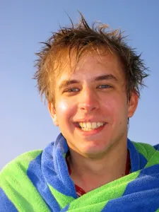 Happy: Portrait of a smiling man on summer holiday wrapped in a towel