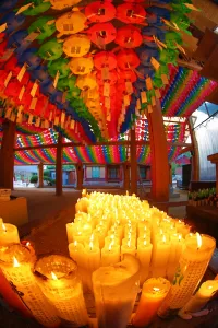 Seoul, Korea: Rainbow coloured paper lanterns and candles at an altar in Bongeunsa Temple in Seoul