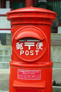 Service: A red postbox at Itsukushima Shinto Shrine on Miyajima Island, Hiroshima, Japan