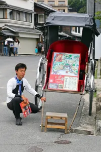 Hiroshima, Japan: A rickshaw and its driver at Itsukushima Shinto Shrine on Miyajima Island