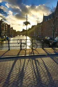 Silhouette of a parked bicycle and its shadow on a bridge over a canal in Amsterdam, Holland