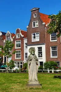 Amsterdam: Statue of Jesus Christ and traditional Dutch houses in Begijnhof in Amsterdam, Holland