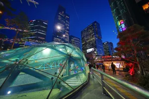 Architecture: Tall modern buildings and office blocks at dusk with the glass of Gangnam metro station
