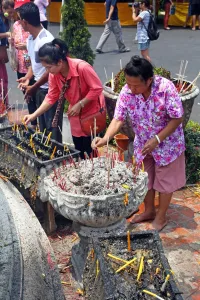 Worship: Women burning incense at Wat Phra Singh Temple in Chiang Mai, Thailand